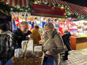 Michl Müller schreibt lächelnd Autogramme. Die Frau neben ihm freut sich schon. 