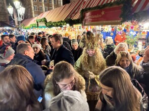 Das Nürnberger Christkind und Marcus König stehen inmitten einer Unmenge an Marktbesuchern.