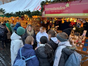 Lea Paulick und Franzi Mai umringt von einer Traube junger weiblicher Fans vor dem Sternstunden-Stand.