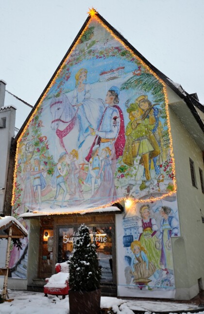 Die Fassade der Landshuter Suppenküche und der rote Sessel im Schnee.