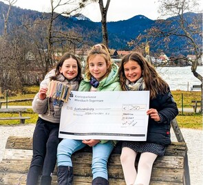 Julia, Anja und Helena halten den Spendenscheck in Händen