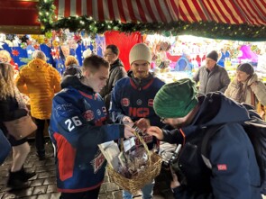 Bei zwei Spielern der Nürnberg Ice Tigers , die ihre Trikots tragen, wird Geld in die Spendenbox geworfen
