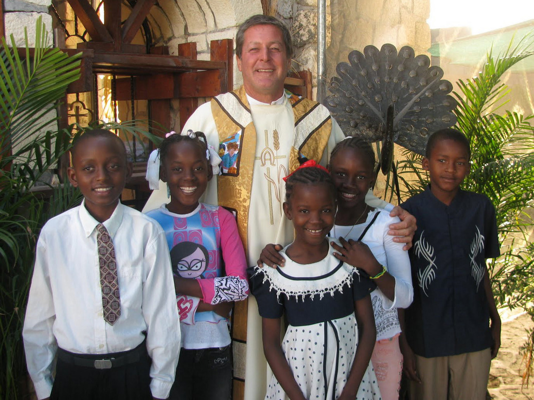 Pater Richard und einige Kinder. Er informiert Sternstunden über die anstehenden Arbeiten.