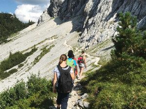 Jugendliche von hinten beim Wandern in den Bergen