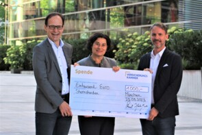 Volkmar Kriesch, Isabella Martorell Naßl und Florian Babel halten einen großen Scheck über 1000 Euro auf dem Campus der Versicherungskammer.