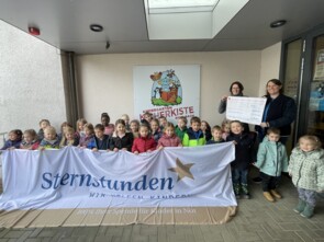 Gruppenbild: Kinder und Erzieherin spenden 300 Euro an Sternstunden.