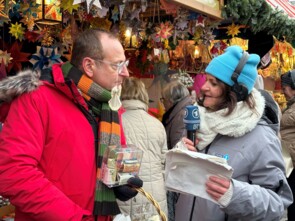 Die Bayern 1-Repoterin rechts interviewt Volker Heißmann links live vor dem Sternstunden-Stand.