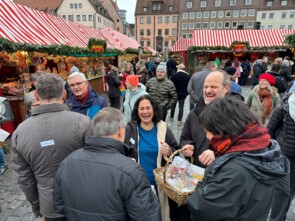 Ines Procter und Andreas Leopold Schadt lachen herzlich, im Vordergrund Marktbesucher von hinten