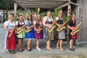 Sieben Frauen in Tracht mit Saxophonen