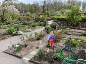 Ein Garten im Frühling mit vielen Beeten und viel Grün.