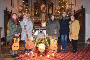 Anlassmusi vor dem Altar einer festlich geschmückten Kirche.